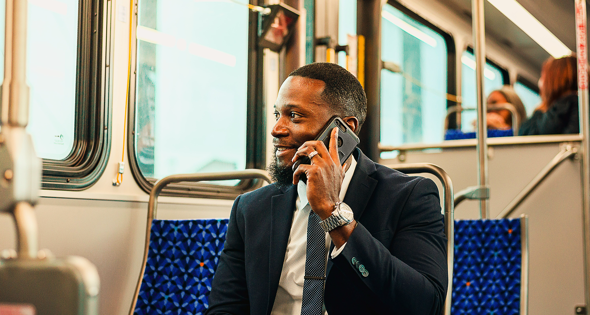 A man sitting in a bus and talking on phone